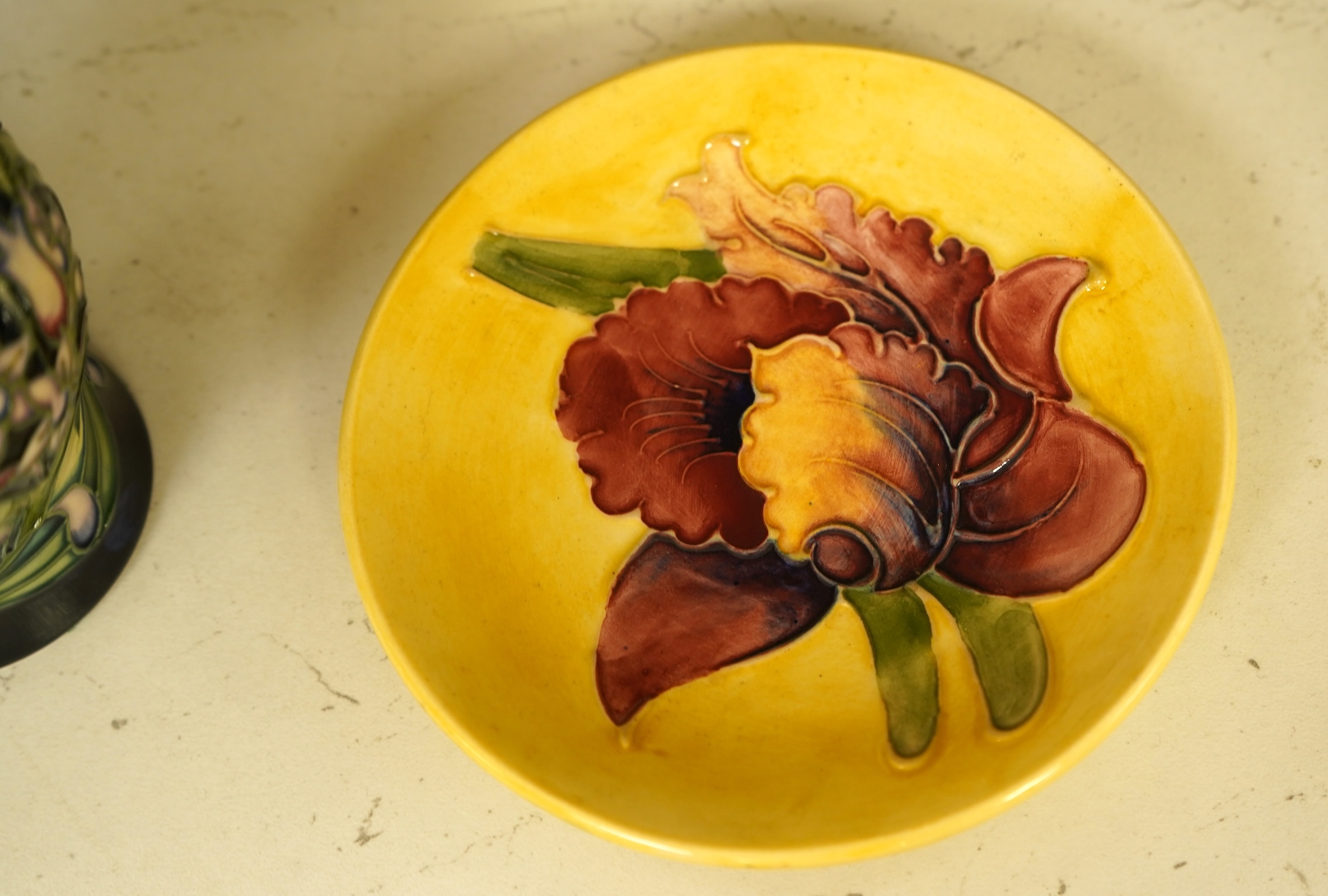 A collection of modern Moorcroft to include a mountain gold pattern vase, two pin dishes and a Hibiscus pattern candlestick, largest 20cm high
